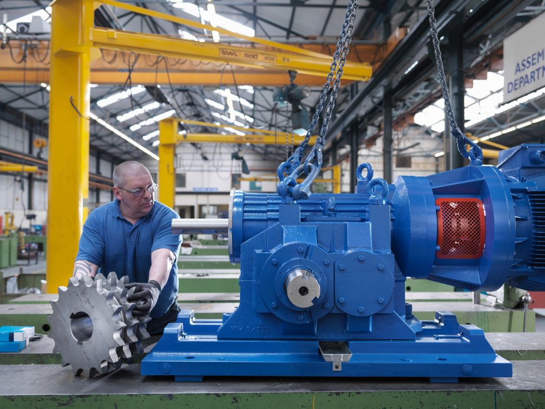 engineer assembling industrial gearbox in engineering factory