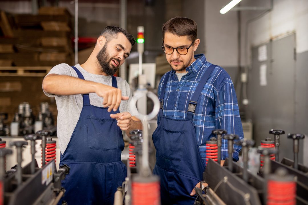 young engineer explaining his trainee how to serve and use technical equipment